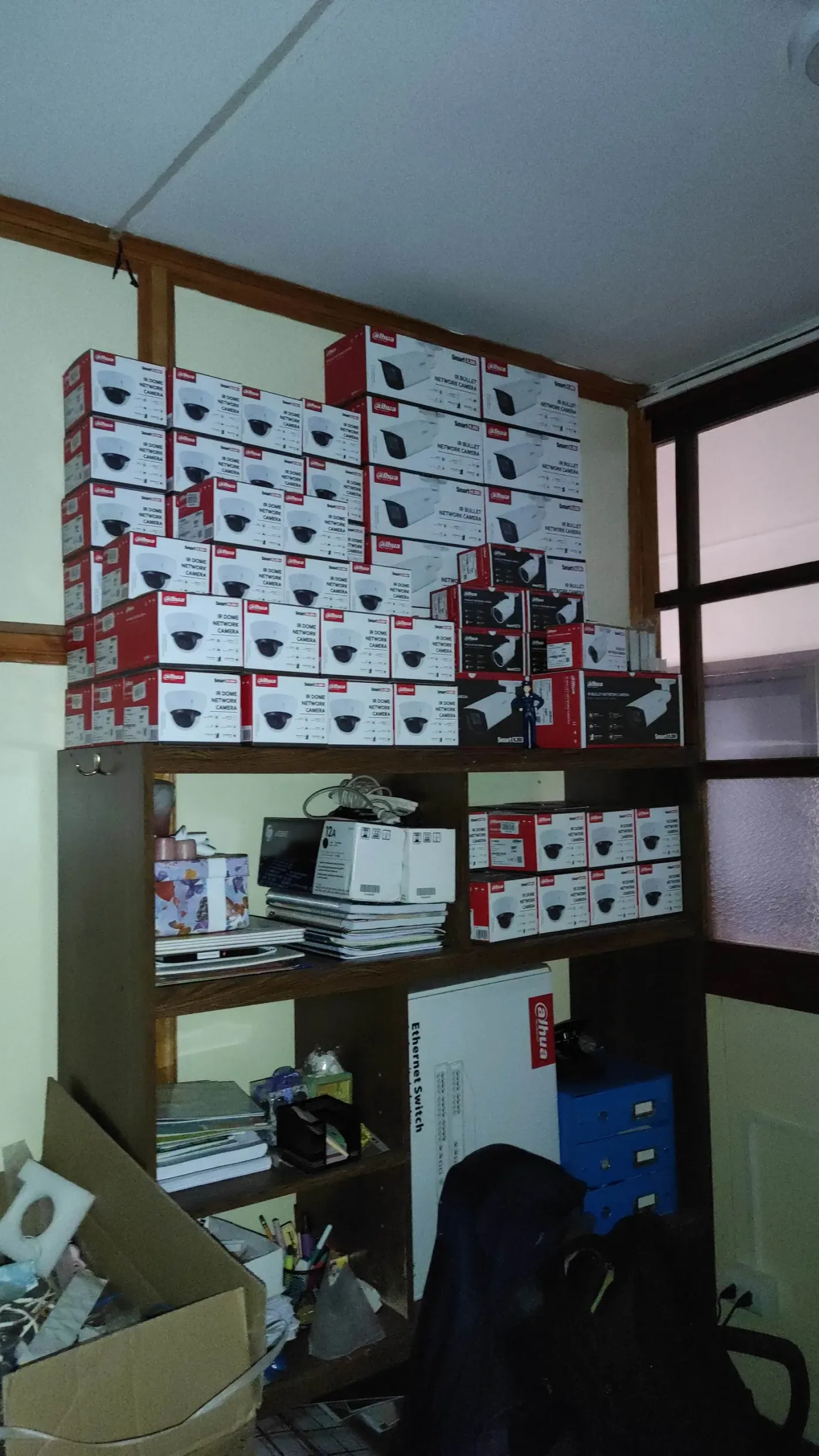 Estantería llena de cajas de cámaras Dahua apiladas en una bodega de stock