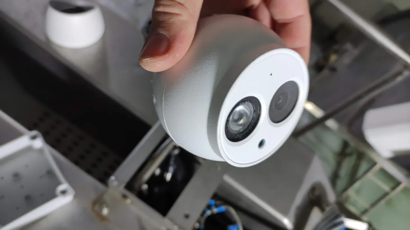 Mano sosteniendo una cámara IP turret de doble lente, mostrando sus dos sensores
