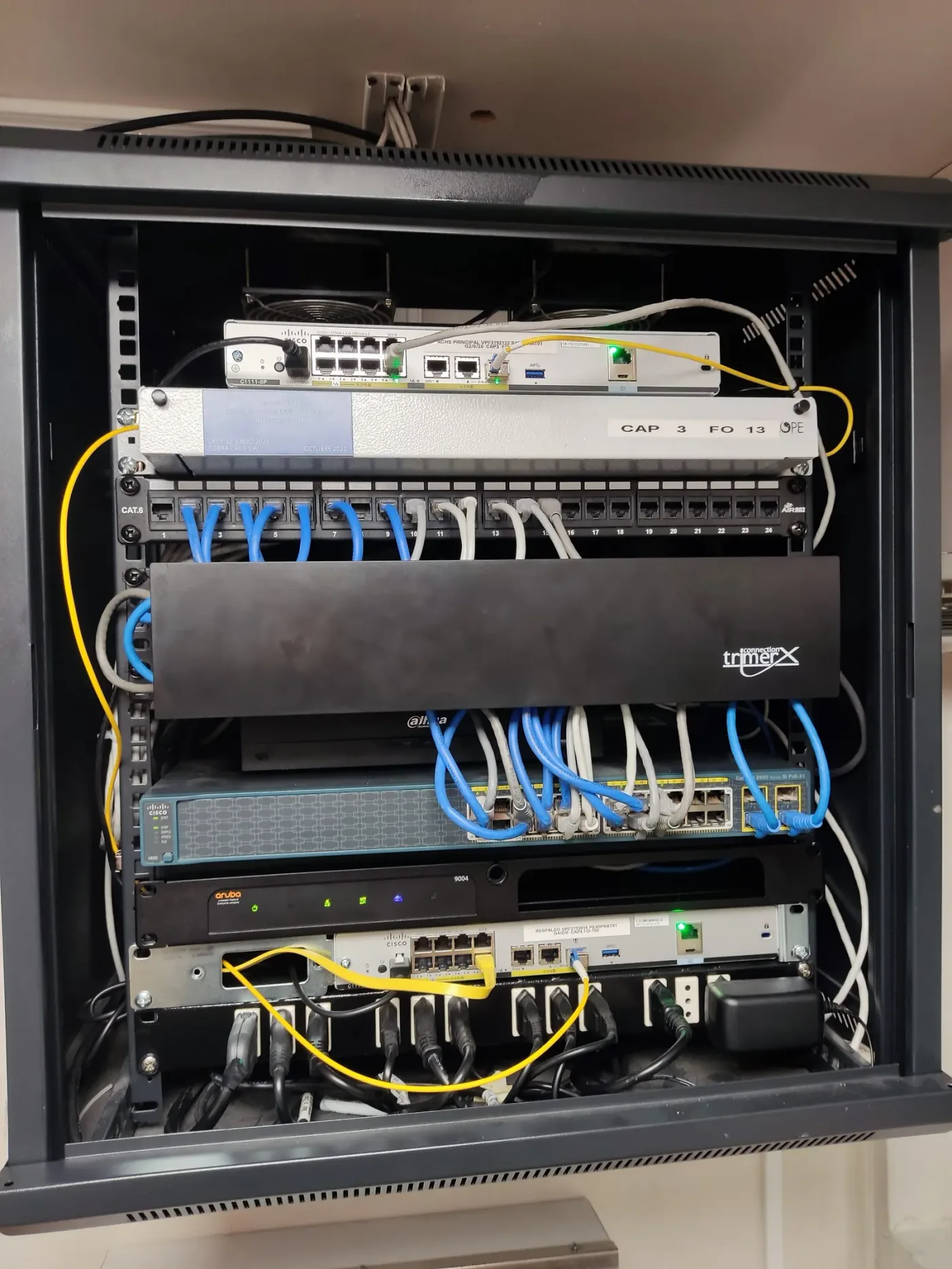 Rack de comunicaciones abierto con switches Cisco y Aruba, cableado y patch panel de red